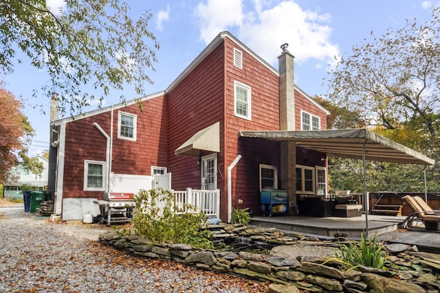 back of house with a jacuzzi and a deck