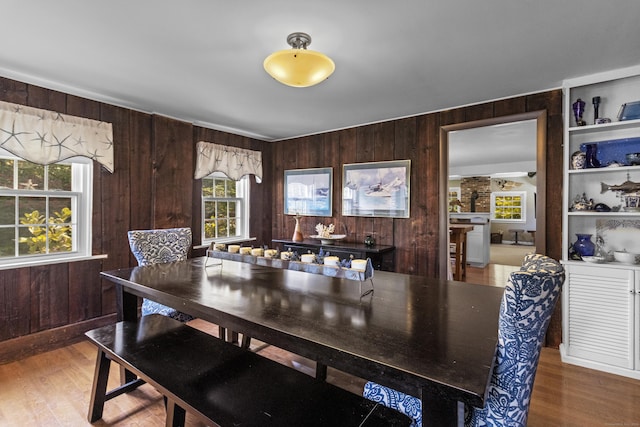 dining room featuring wooden walls, built in features, and hardwood / wood-style floors