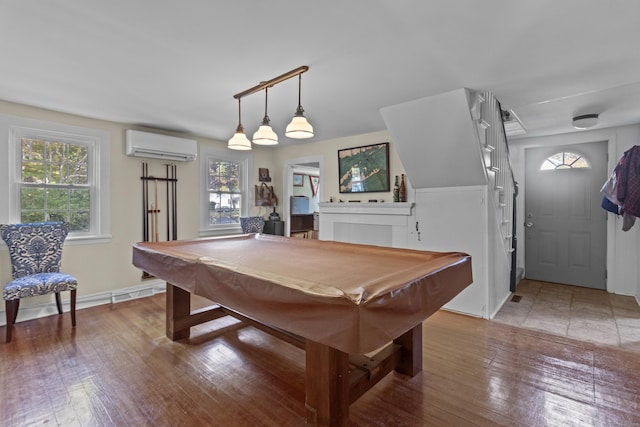 rec room with hardwood / wood-style floors, a wall mounted AC, and pool table