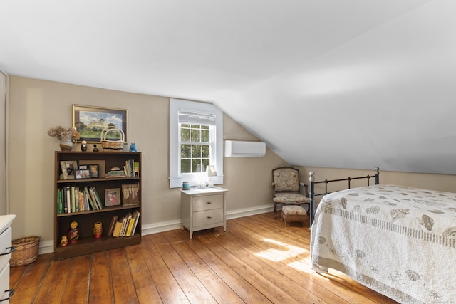 bedroom featuring light hardwood / wood-style flooring, a wall unit AC, and lofted ceiling