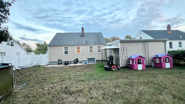 back of property featuring a yard and a patio area