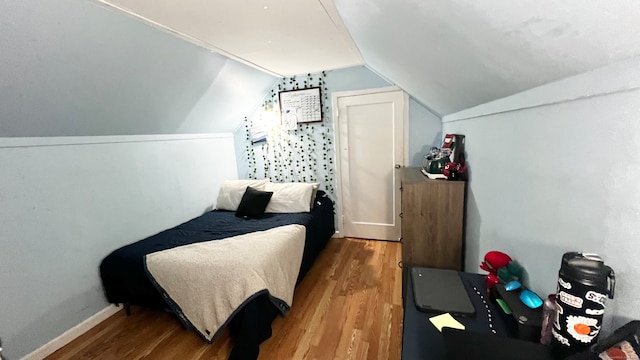 bedroom featuring lofted ceiling and hardwood / wood-style floors