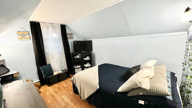 bedroom with vaulted ceiling and wood-type flooring