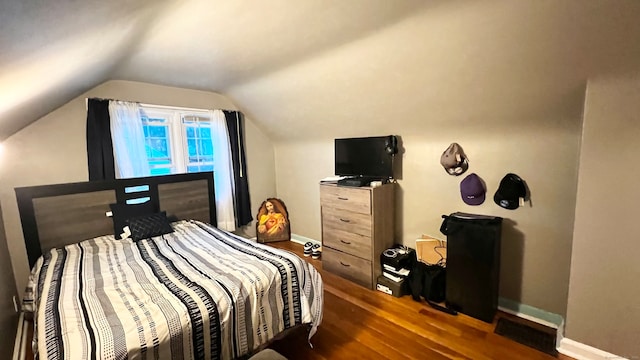 bedroom with lofted ceiling and dark hardwood / wood-style floors