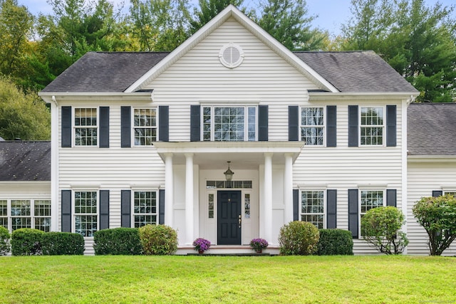 colonial inspired home with a front lawn