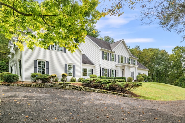 colonial home featuring a front lawn