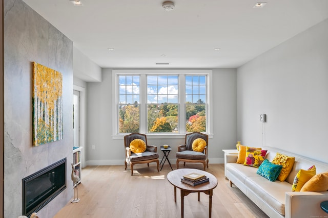 sitting room with a fireplace and light hardwood / wood-style floors