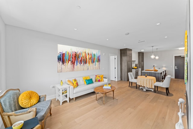 living room with light hardwood / wood-style flooring and a chandelier