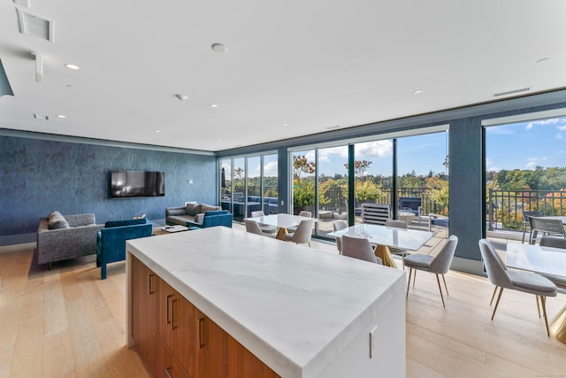 kitchen featuring a kitchen island, light hardwood / wood-style floors, and floor to ceiling windows