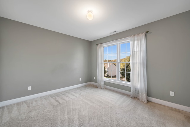 spare room featuring light colored carpet