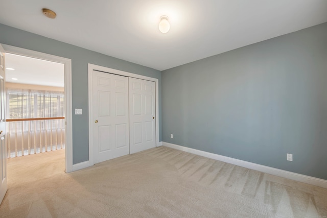 unfurnished bedroom with a closet and light carpet