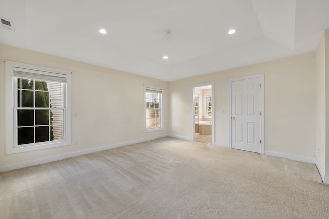 unfurnished bedroom featuring ensuite bathroom and light carpet