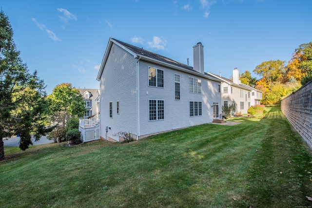 rear view of property featuring a lawn