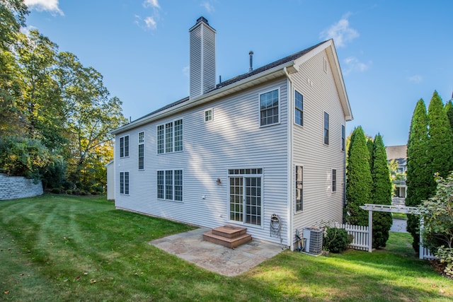 rear view of house with a patio, cooling unit, and a yard