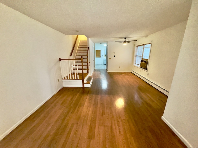 unfurnished living room with a textured ceiling, wood-type flooring, a baseboard radiator, and ceiling fan