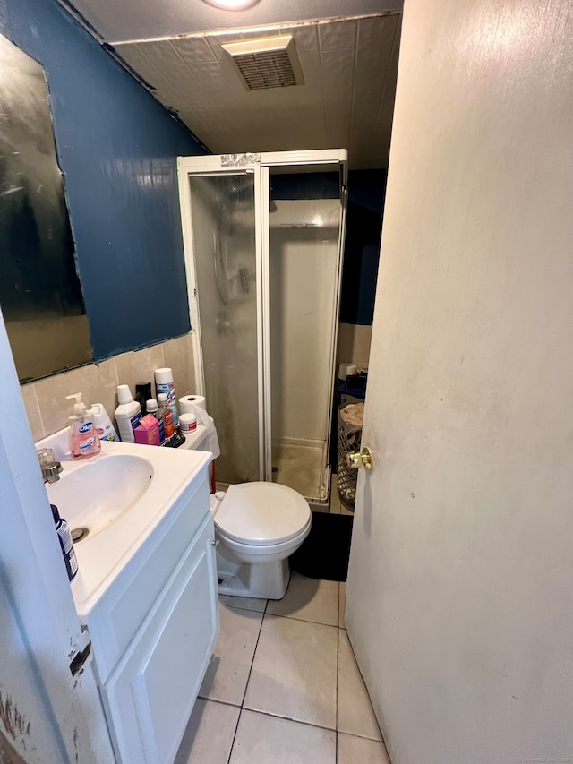 bathroom featuring vanity, toilet, tile patterned flooring, and an enclosed shower