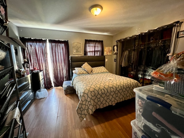 bedroom with multiple windows and wood-type flooring