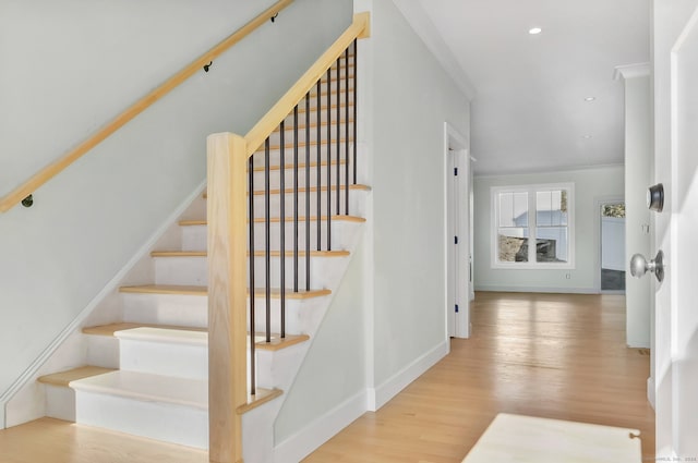 stairway featuring hardwood / wood-style floors and ornamental molding