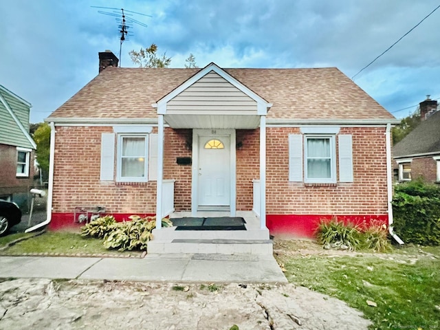 bungalow-style home with a front lawn