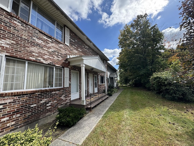 view of side of home with a lawn and brick siding