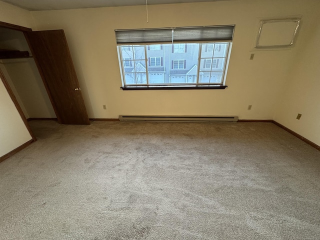 carpeted empty room featuring a baseboard radiator and baseboards