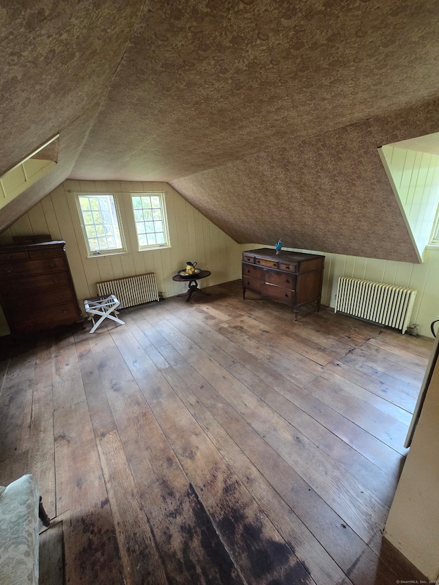 bonus room featuring radiator, hardwood / wood-style flooring, and lofted ceiling