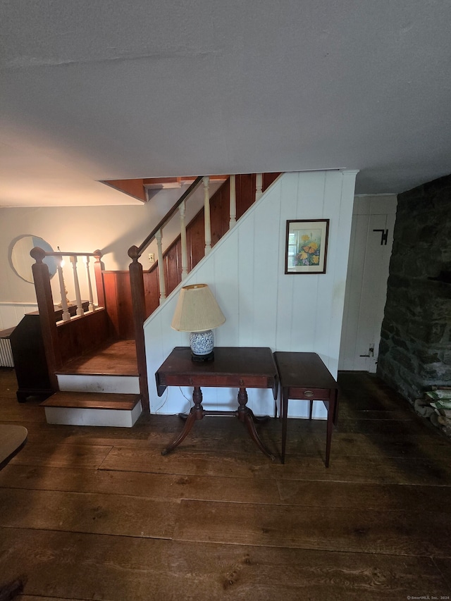 stairway featuring a textured ceiling and hardwood / wood-style flooring