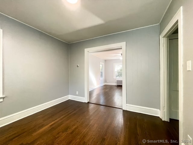 unfurnished room with radiator and dark hardwood / wood-style flooring