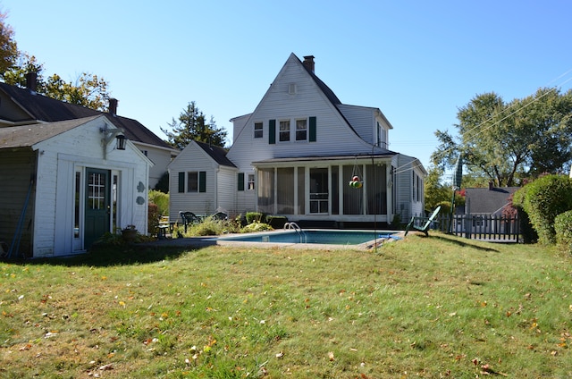 back of house featuring a yard and a sunroom