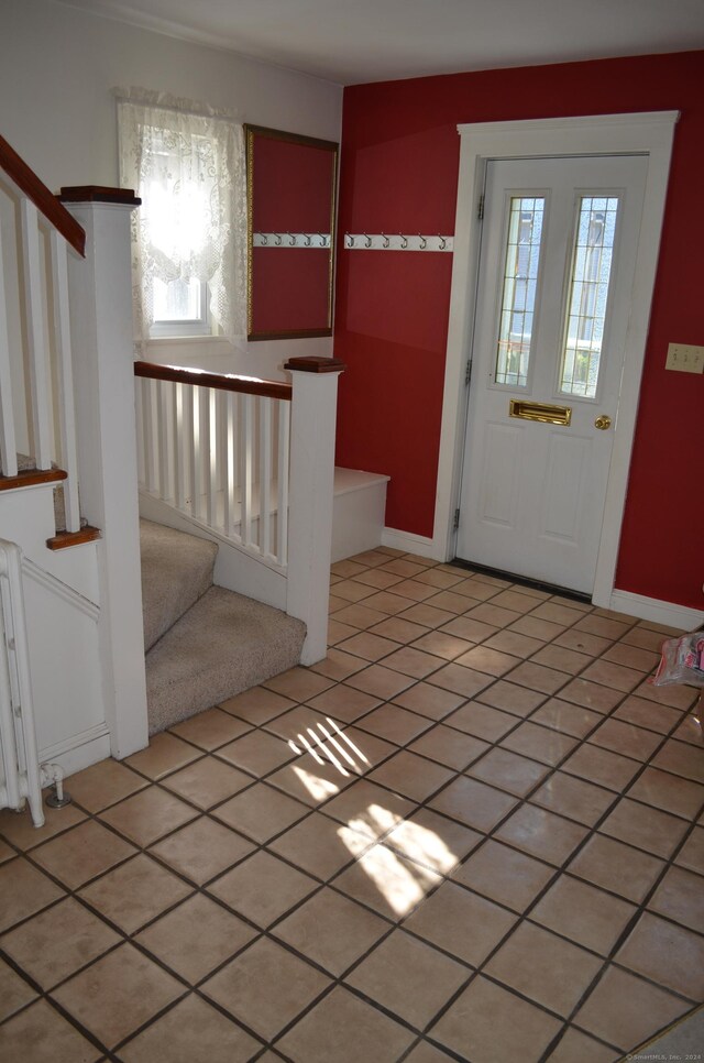 entrance foyer with a wealth of natural light, tile patterned flooring, and radiator