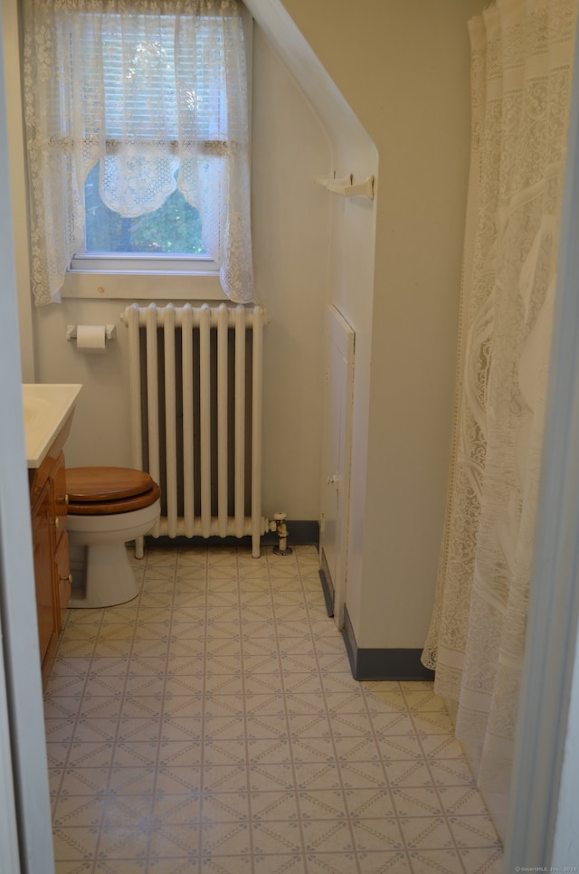 bathroom featuring toilet, vanity, and radiator