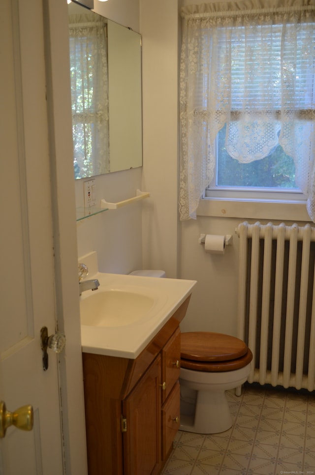 bathroom featuring radiator, toilet, and vanity