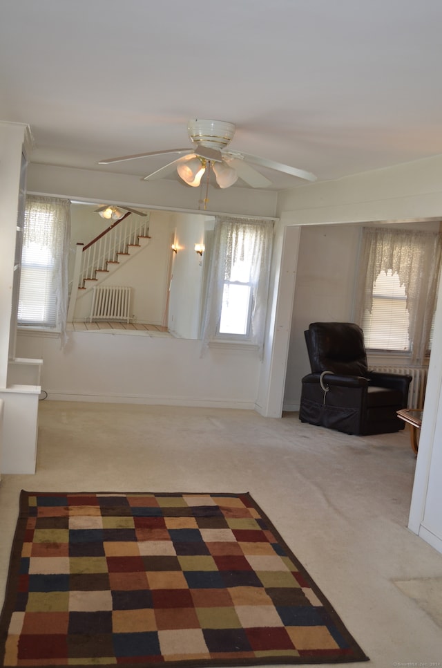 living room with cooling unit, carpet flooring, and ceiling fan