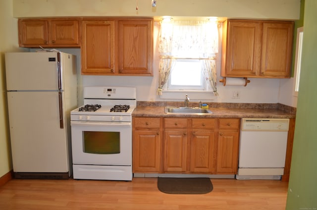 kitchen with sink, light wood-type flooring, and white appliances