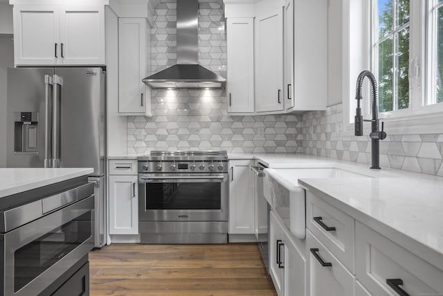 65 Soderman Way Unit 65, Cheshire, CT 06410 - kitchen with appliances with stainless steel finishes, wall chimney exhaust hood, a sink, white cabinets, and light stone countertops