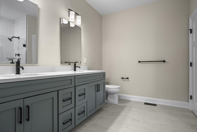 65 Soderman Way Unit 65, Cheshire, CT 06410 - bathroom featuring double vanity, a tile shower, toilet, baseboards, and tile patterned flooring