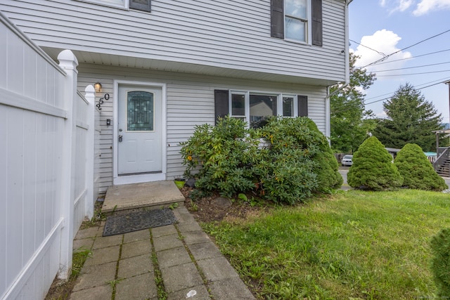 view of exterior entry with a yard