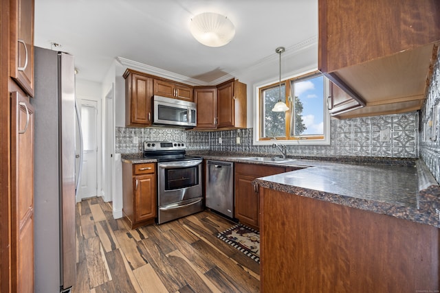 kitchen with backsplash, stainless steel appliances, dark wood-type flooring, sink, and decorative light fixtures