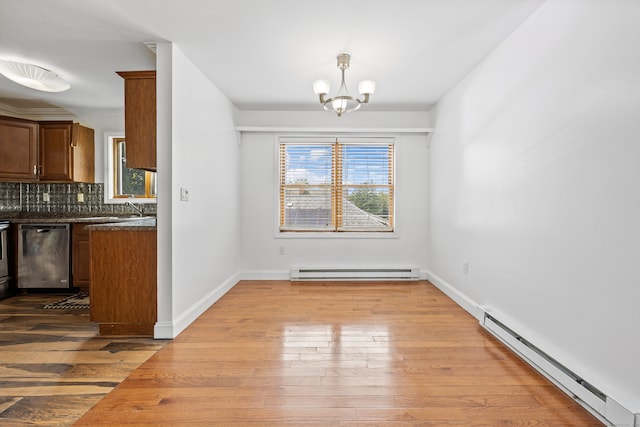 unfurnished dining area featuring baseboard heating, hardwood / wood-style floors, and a chandelier