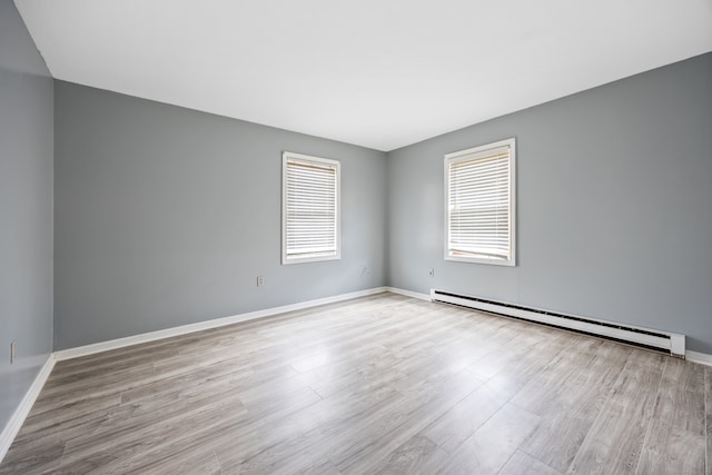 unfurnished room with light hardwood / wood-style flooring and a baseboard heating unit