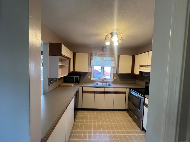 kitchen with a textured ceiling, sink, stainless steel appliances, and extractor fan