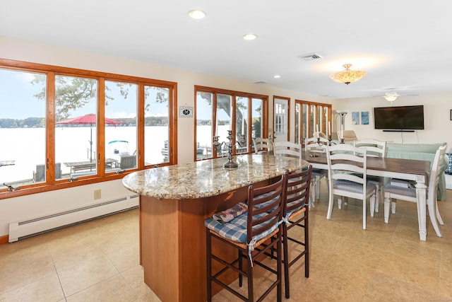 199 Pine Hollow Rd, Killingly, CT 06241 - kitchen with a baseboard radiator, light stone countertops, recessed lighting, a kitchen bar, and a kitchen island