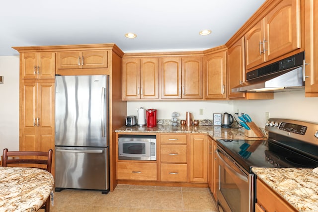 kitchen featuring stainless steel appliances, light stone countertops, and light tile patterned floors