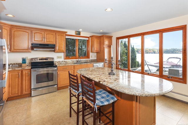 199 Pine Hollow Rd, Killingly, CT 06241 - kitchen with stainless steel electric range oven, under cabinet range hood, light stone counters, a kitchen island, and a kitchen breakfast bar