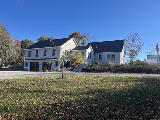 view of front facade featuring a garage, driveway, and a front yard