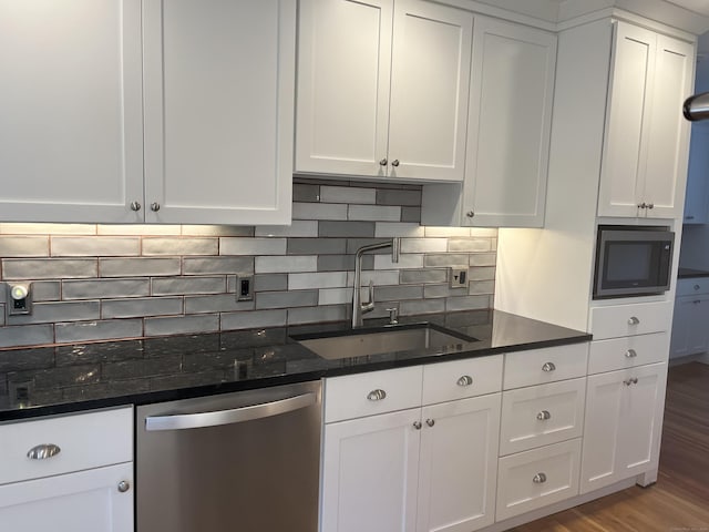 kitchen with decorative backsplash, built in microwave, white cabinets, a sink, and dishwasher