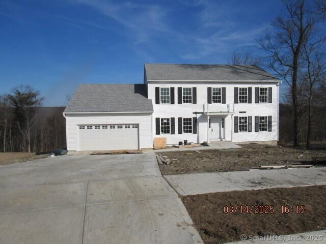 colonial house with driveway and a garage