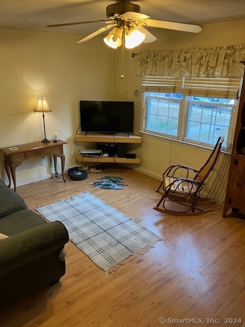 living room featuring light wood-type flooring and ceiling fan