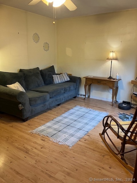 living room featuring hardwood / wood-style floors and ceiling fan