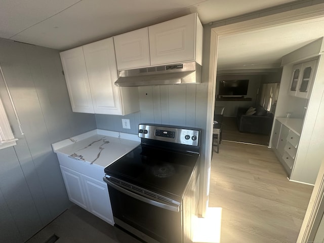 kitchen with range hood, white cabinets, light wood-type flooring, and stainless steel range with electric cooktop